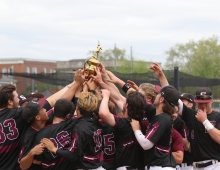 baseball players hold a trophy aloft